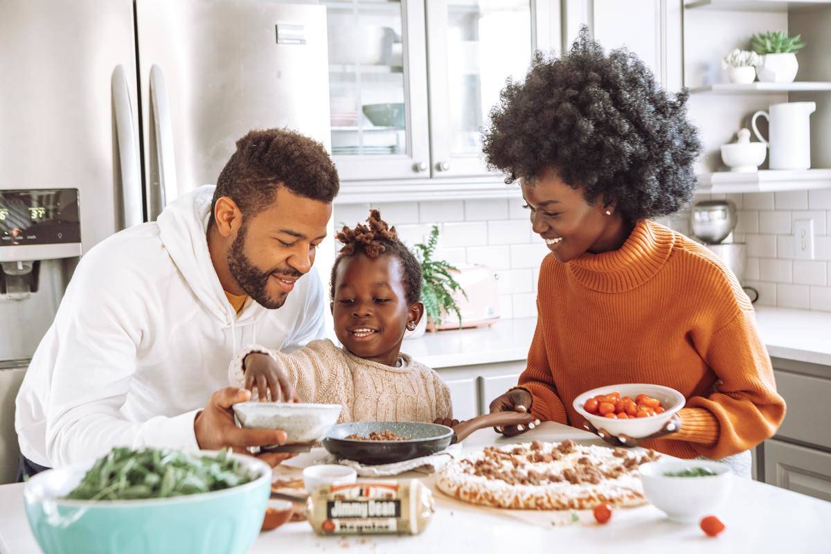 Mother, father, and young child cooking together