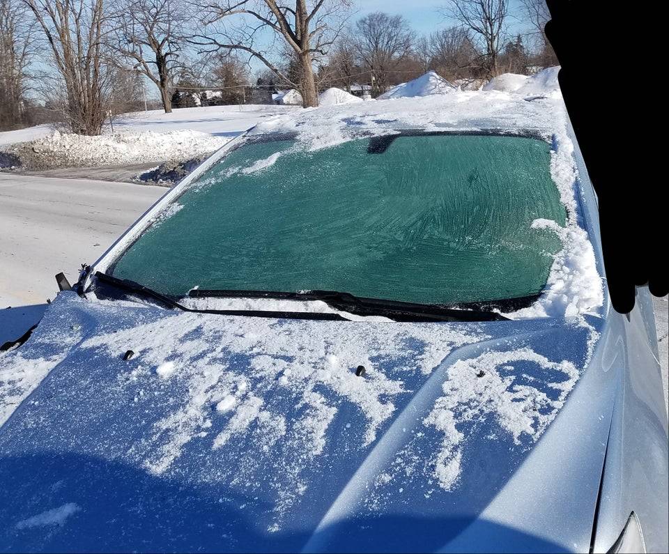Car with snow and ice on the roof and windshield 