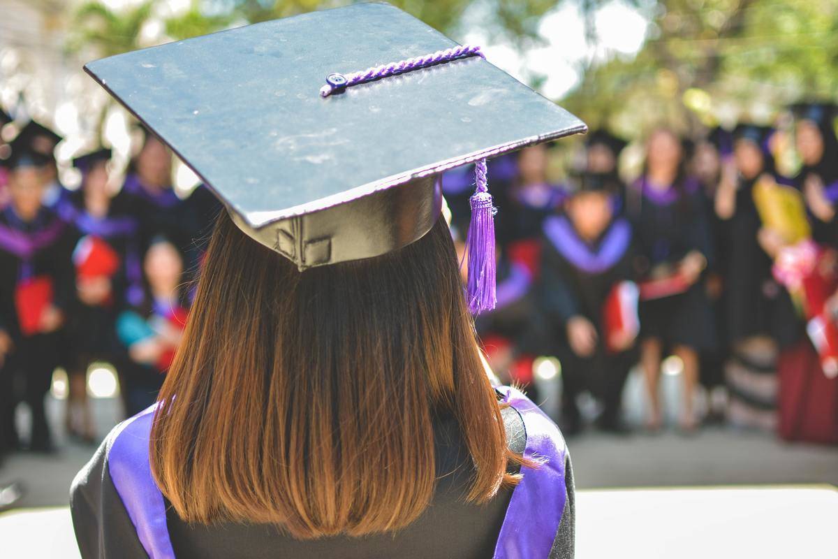 Woman wears graduation cap on graduation day 