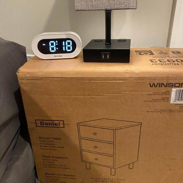 using box with unassembled nightstand as bedside table