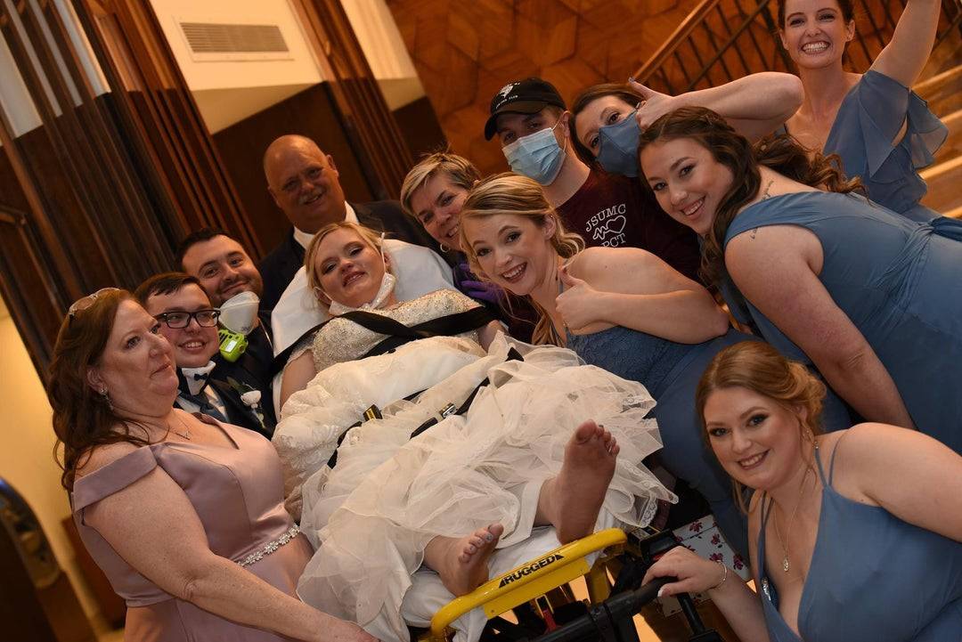 Bride in a stretcher surrounded by family all smiling