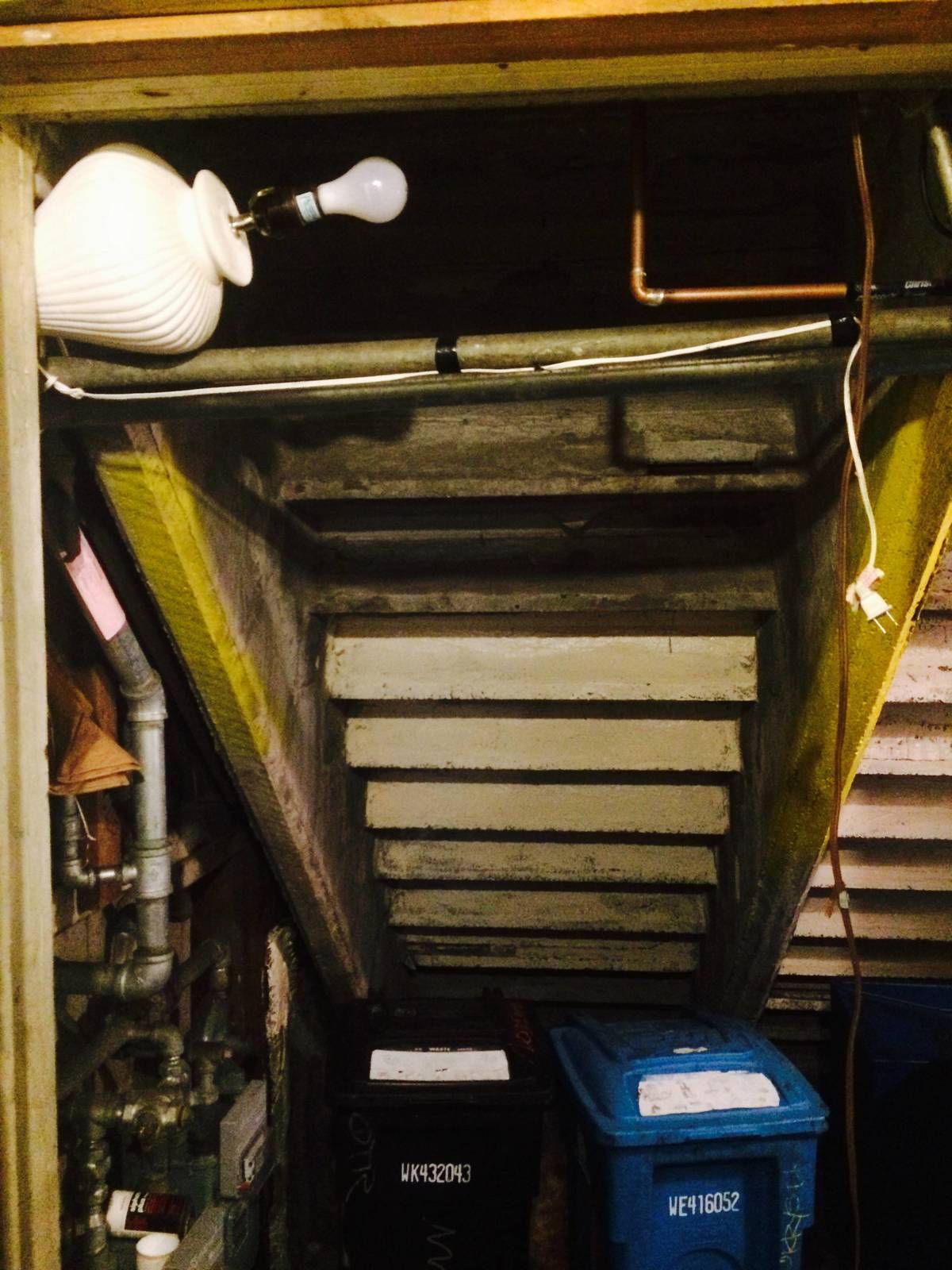 Lamp wedged in ceiling to act as lighting fixture, exposed bulb