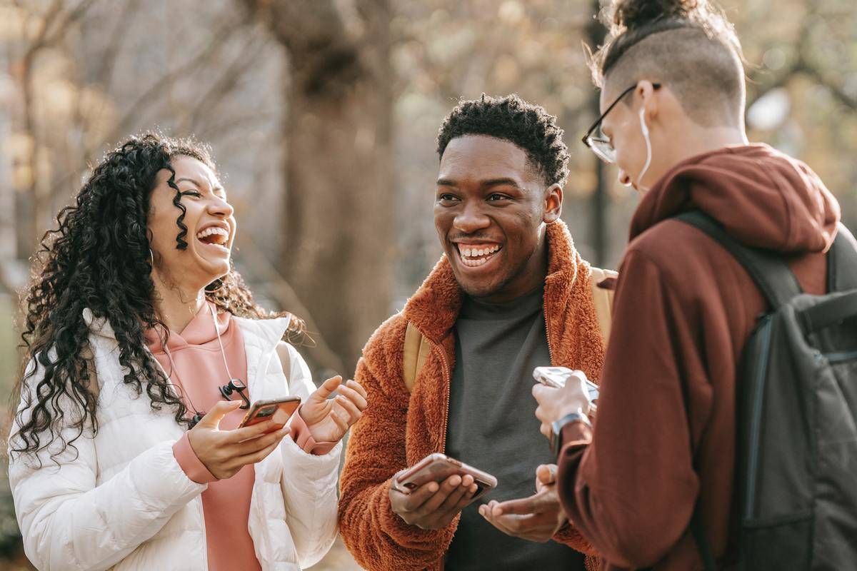 Group of three people outside laughing