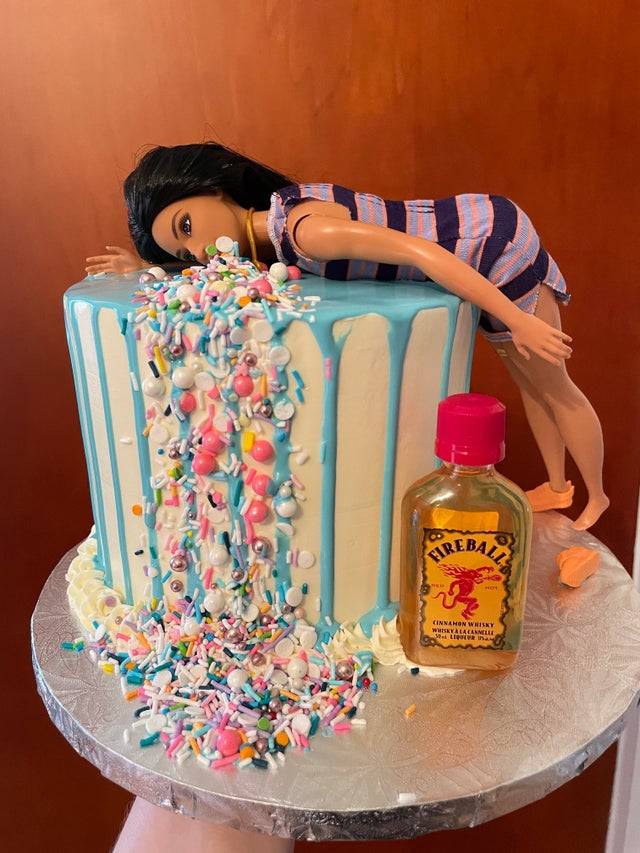 Cake decorated to look like a Barbie is vomiting sprinkles and includes a mini bottle of Fireball