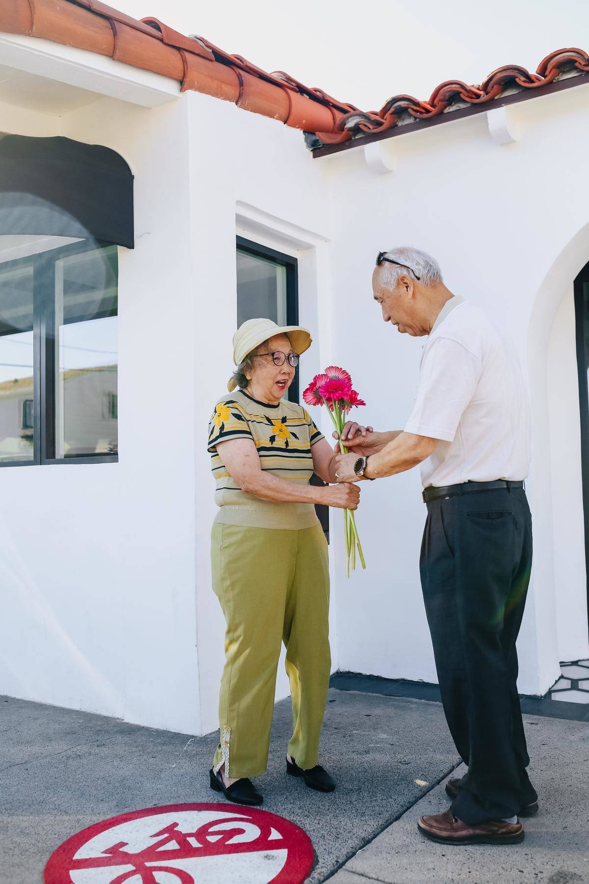 Man gives his wife a bouquet of pink flowers