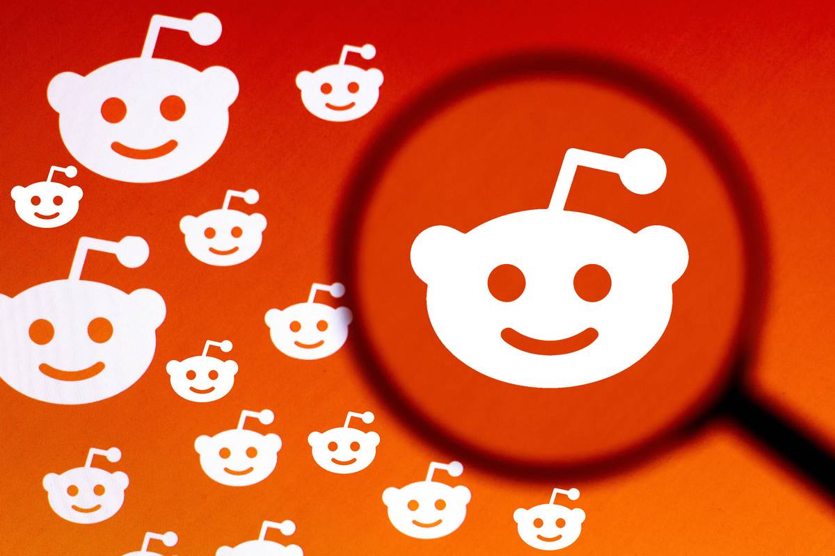 In this photo illustration the Reddit logo seen displayed on a computer screen through a magnifying glass. 