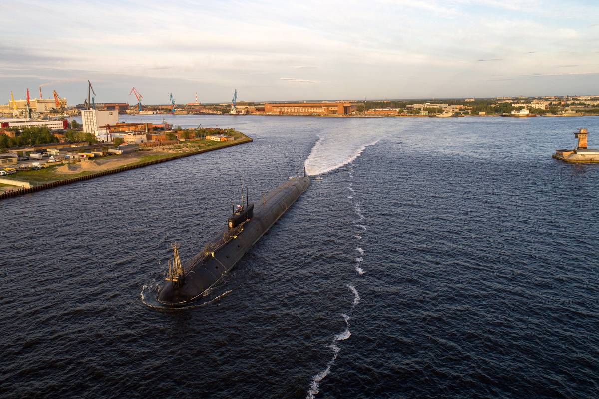 A Russian naval submarine glides across a bay.