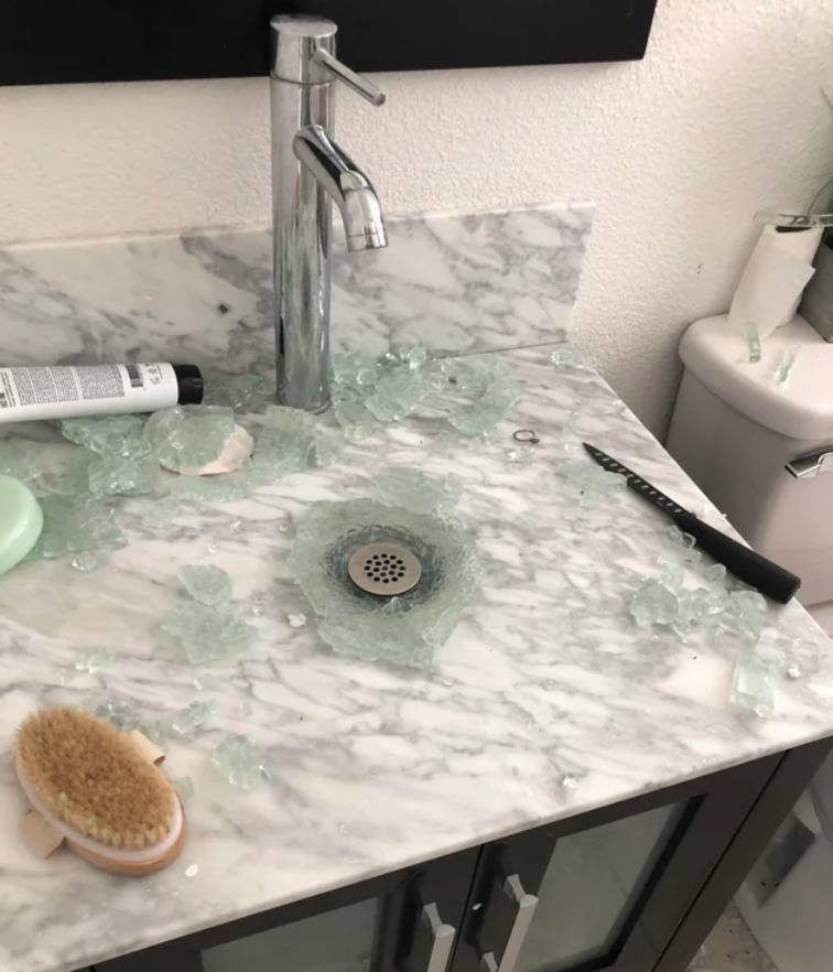 glass bathroom sink shattered in fragments