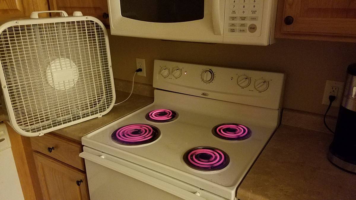 Four stove burners on high, glowing red, fan blowing behind