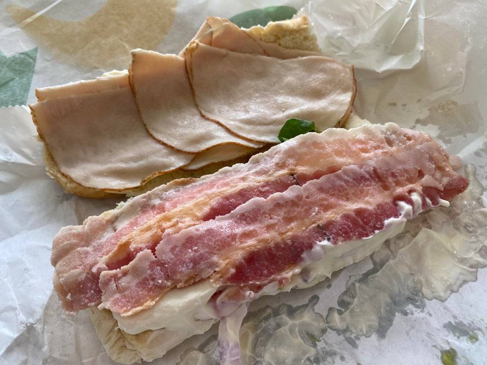 Sub sandwich with what looks to be undercooked bacon on it