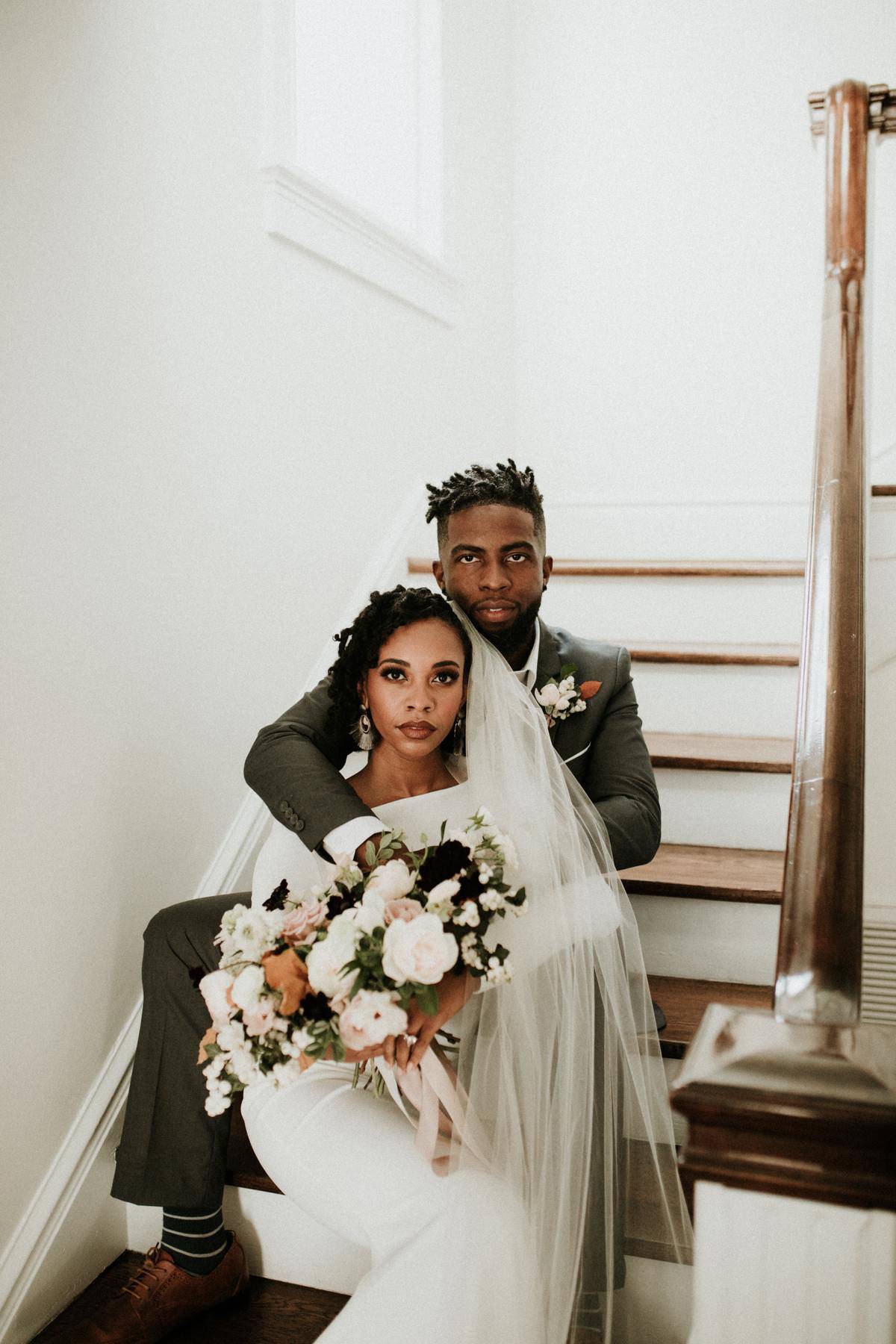 Bride and groom on wedding day seated on staircase