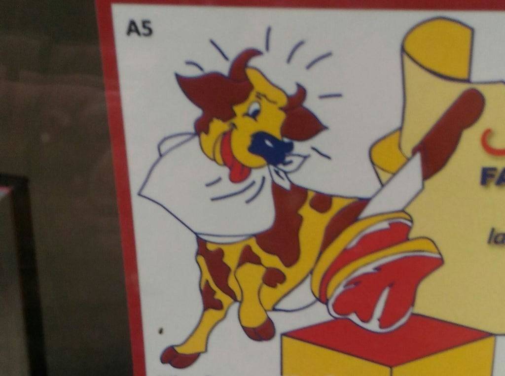 cow in ad ready to eat a steak that's being cut off of himself