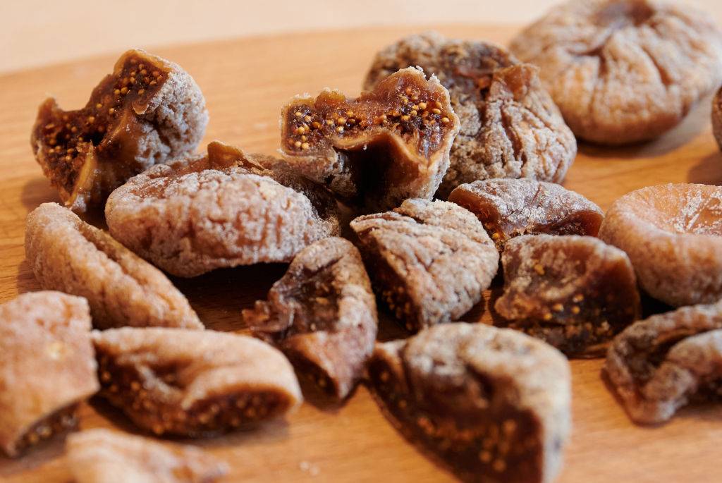 dried figs cut open on a kitchen board