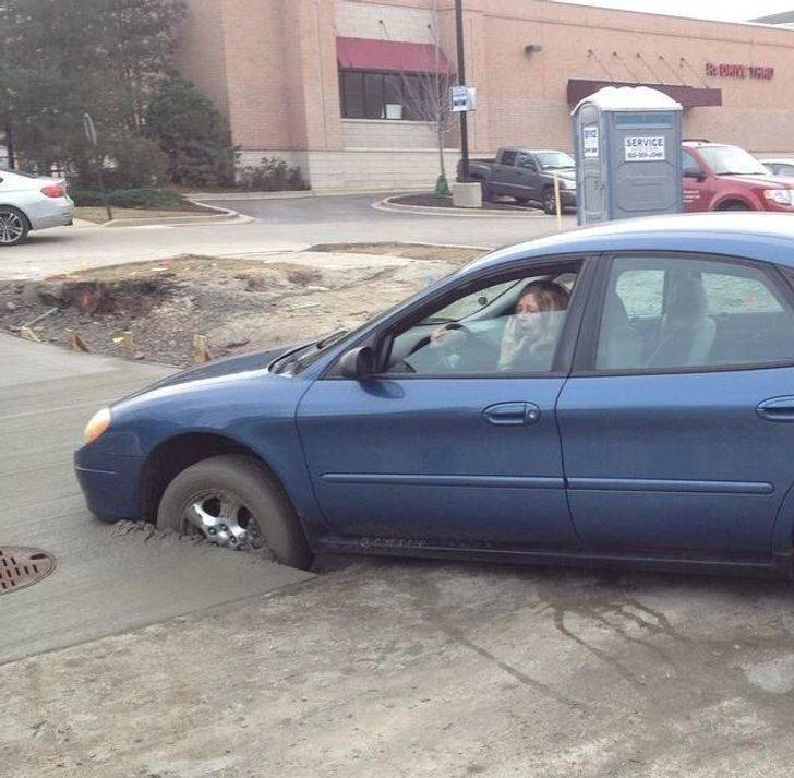 car with front wheels caught in wet concrete