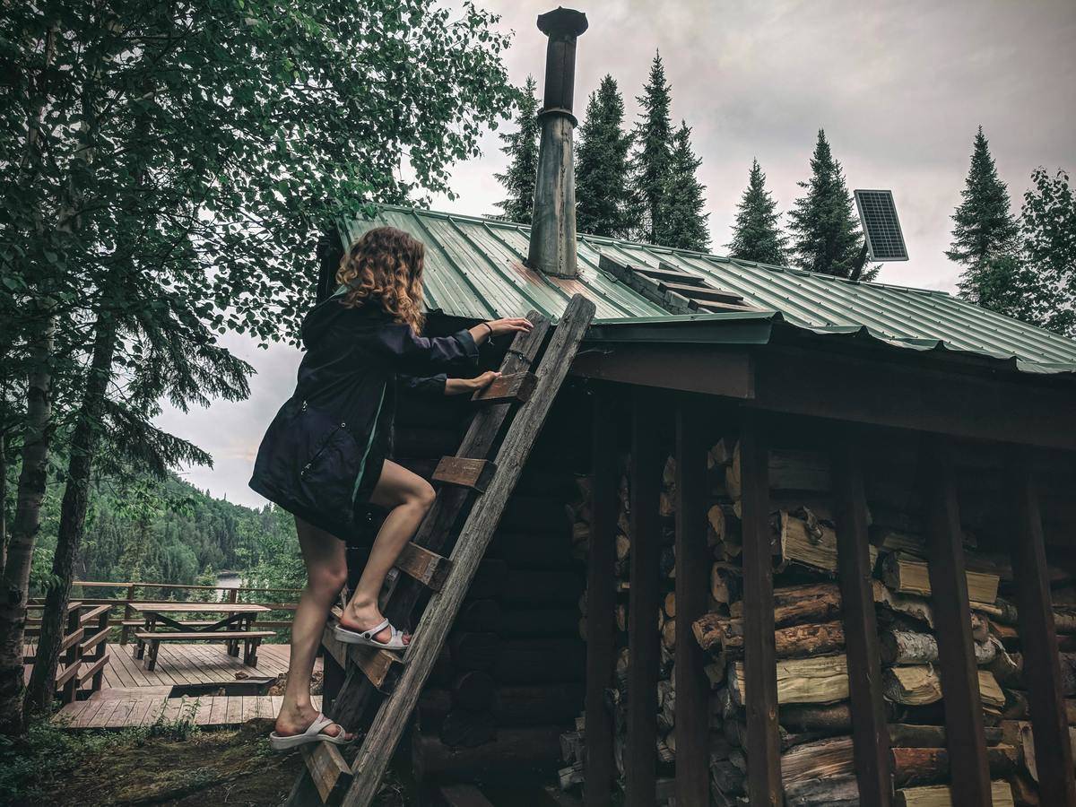 a girl climbing a ladder on the side of a house