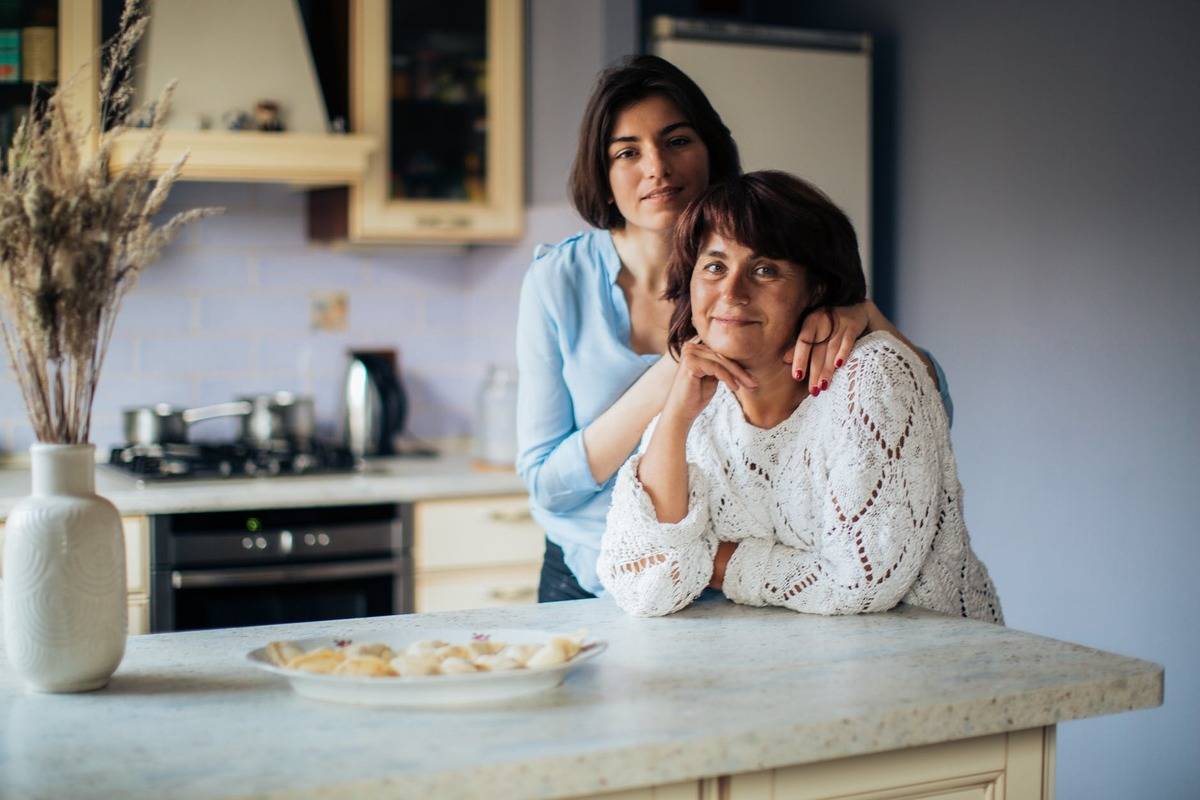 mother and daughter sitting in kitchen