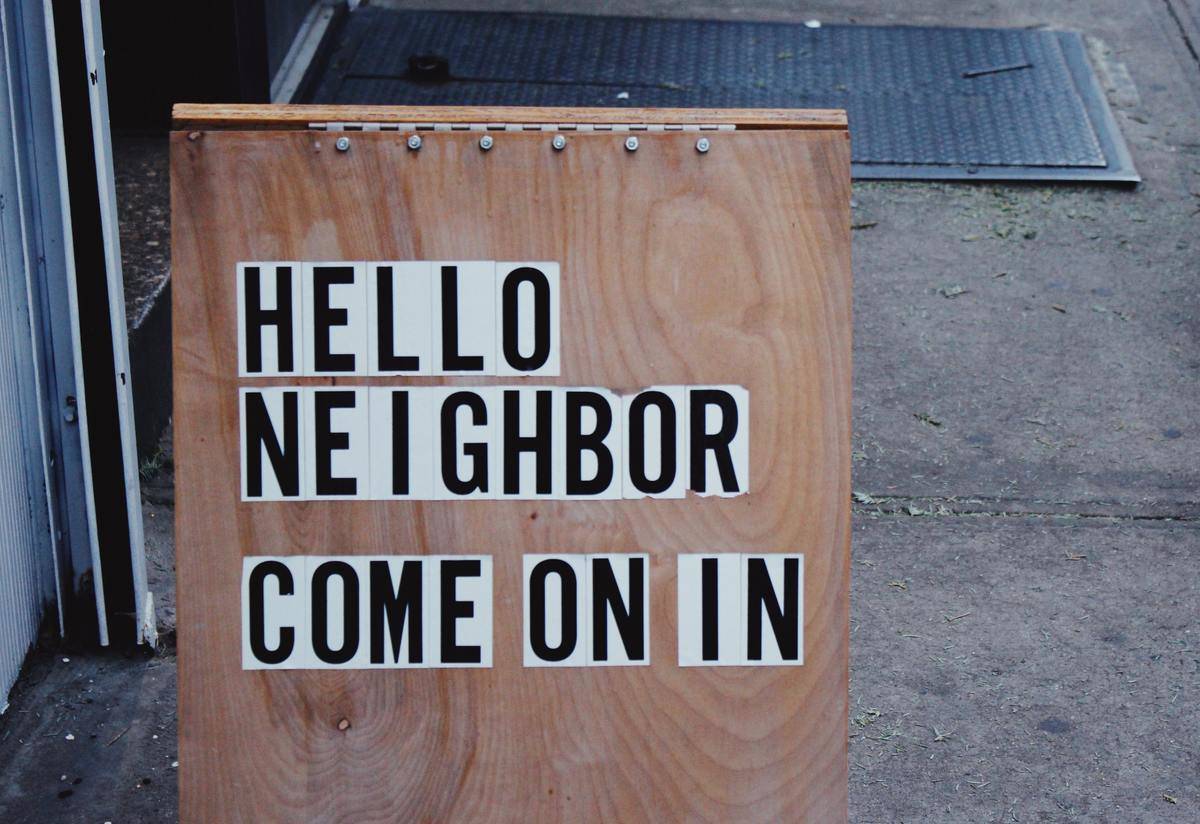 a wood sign that reads Hello neighbor come on in