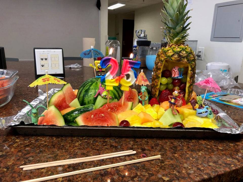 In lieu of a birthday cake, a dieting employee is instead surprised with a birthday fruit platter 