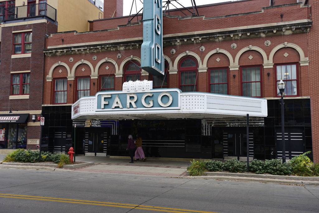 Pedestrians pass in front of the Fargo Theatre in Fargo, North Dakota