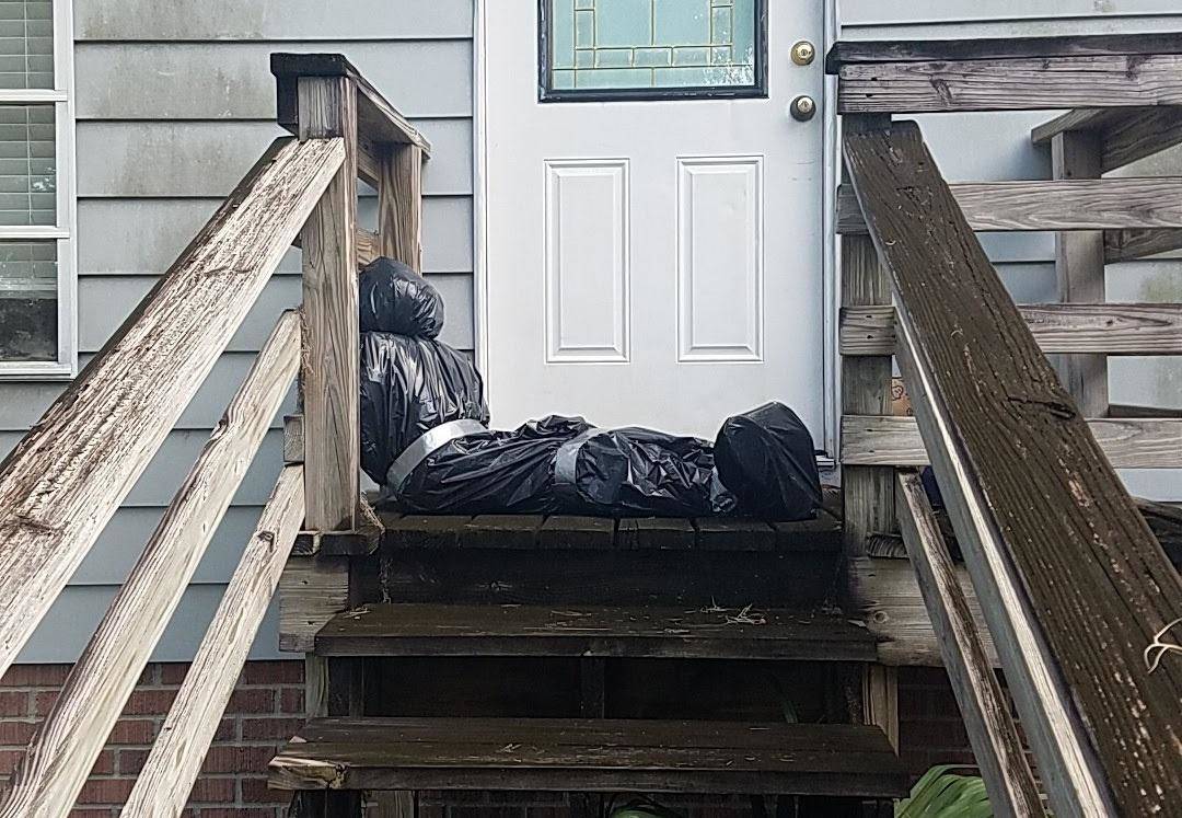 Halloween decoration on front porch of body bag