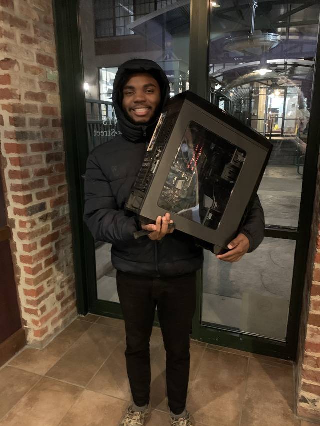 Man is gifted a computer by his new coworker, and is so excited he asks them to take his photo