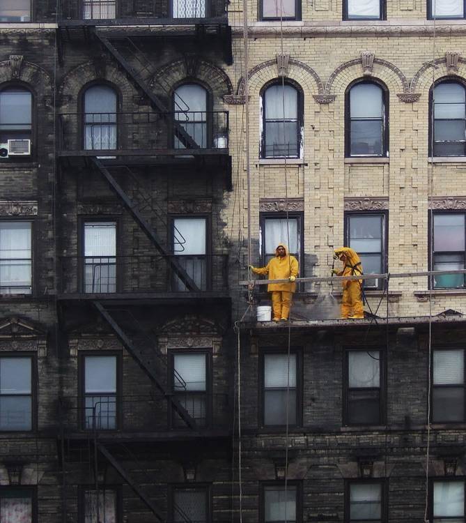 New York sanitation employees power wash a walk up apartment building