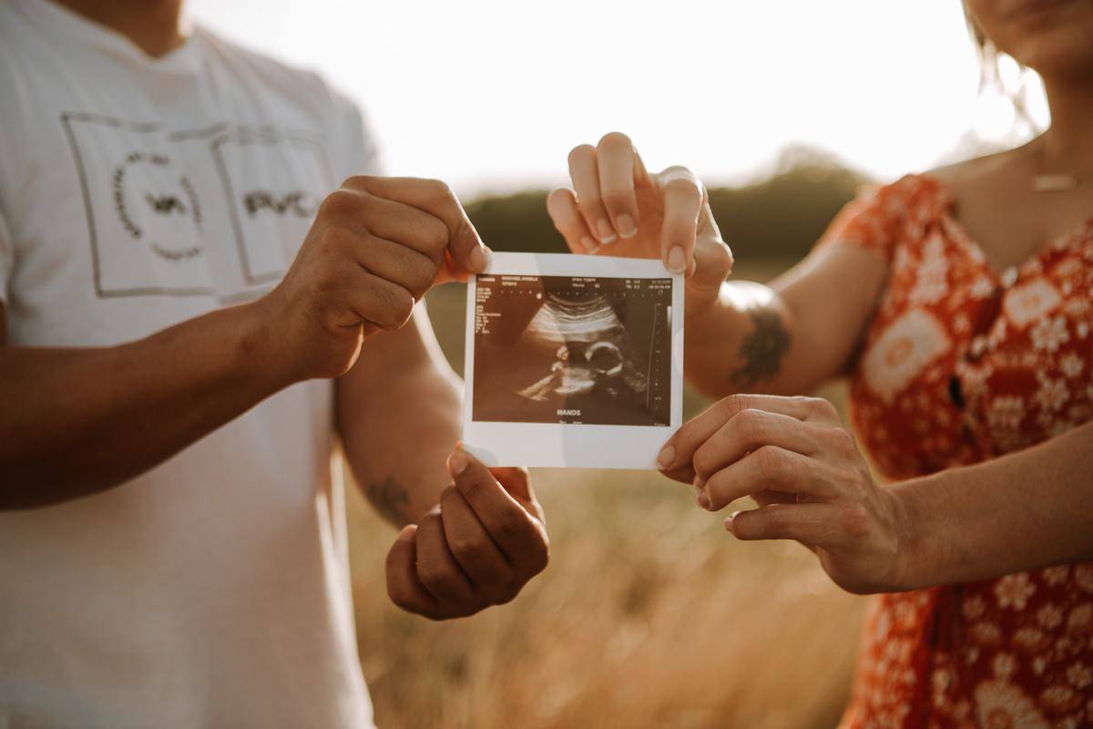 Man and woman hold a photo of an ultrasound 