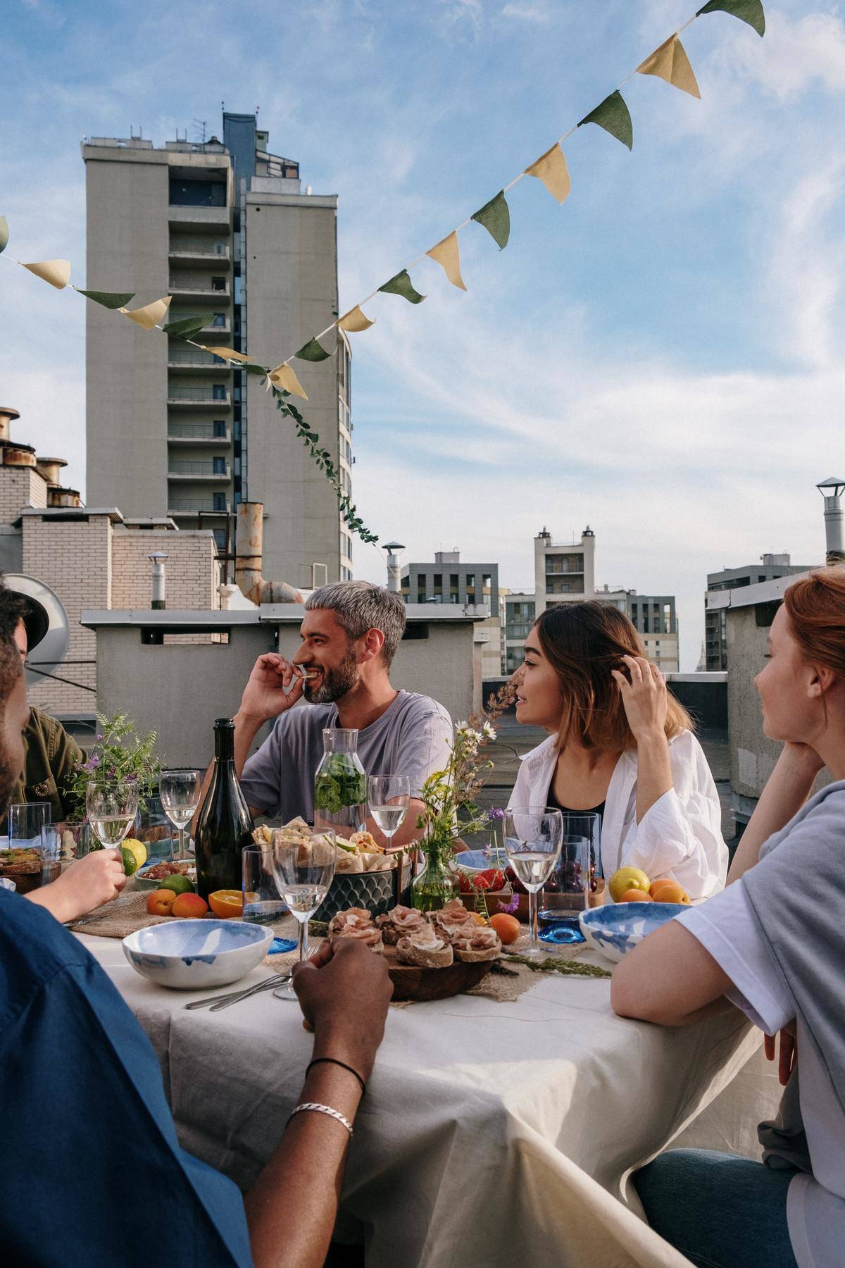 People talking on rooftop at table