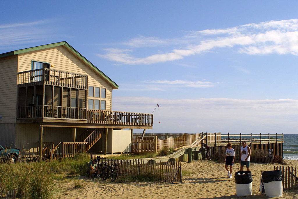 a house on the beach with people walking in the sand in Virginia Beach, Virginia