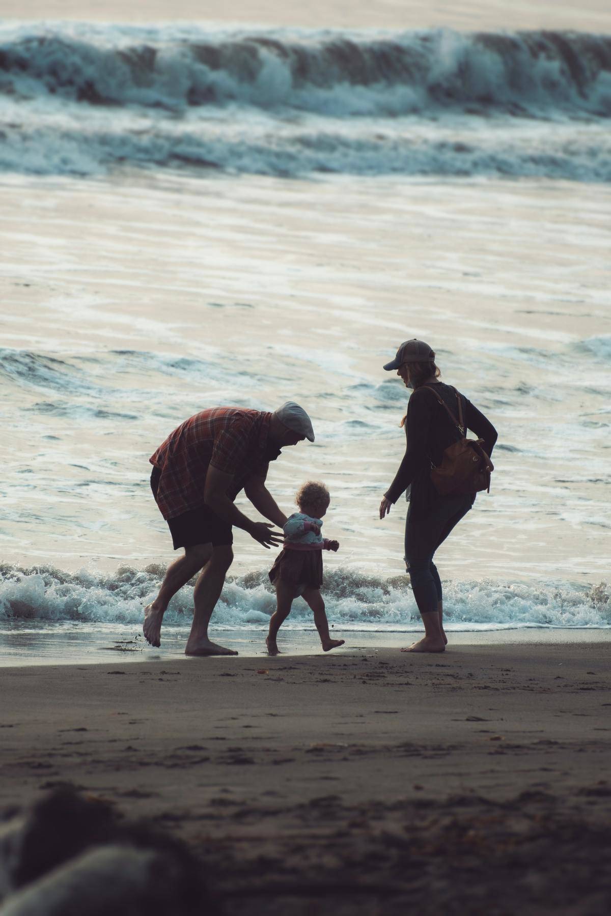 parents with kid at the beach
