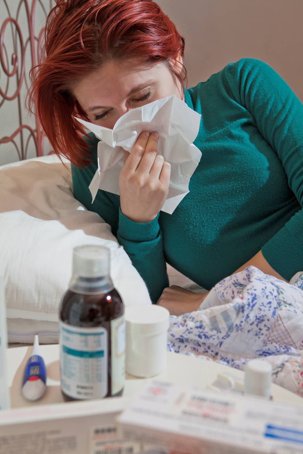A woman with a cold blows her nose.