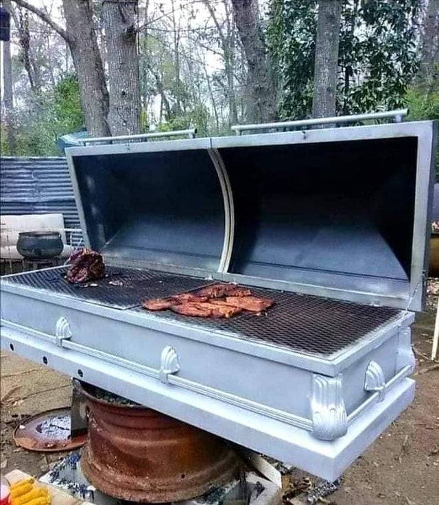 outdoor grill shaped like a casket with meat cooking on it