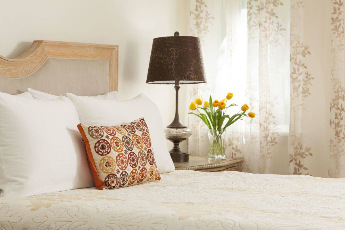 A bedroom is decorate to look and feel cozy.