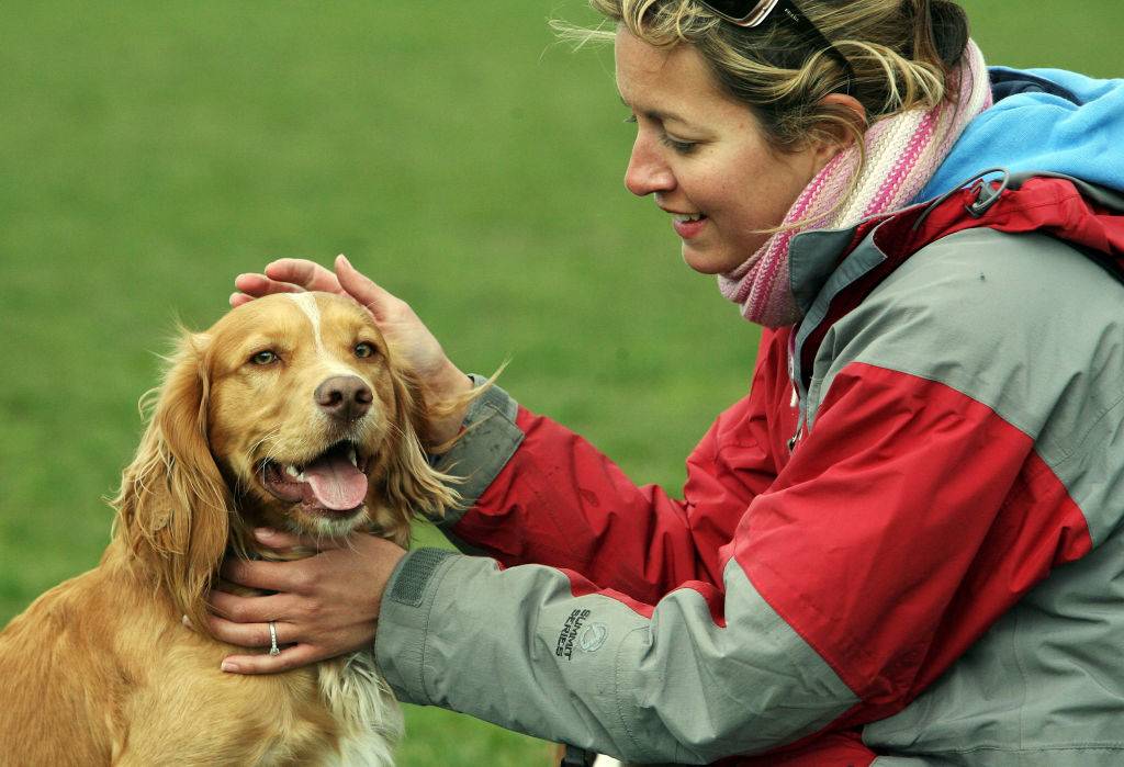 woman petting a dog outside