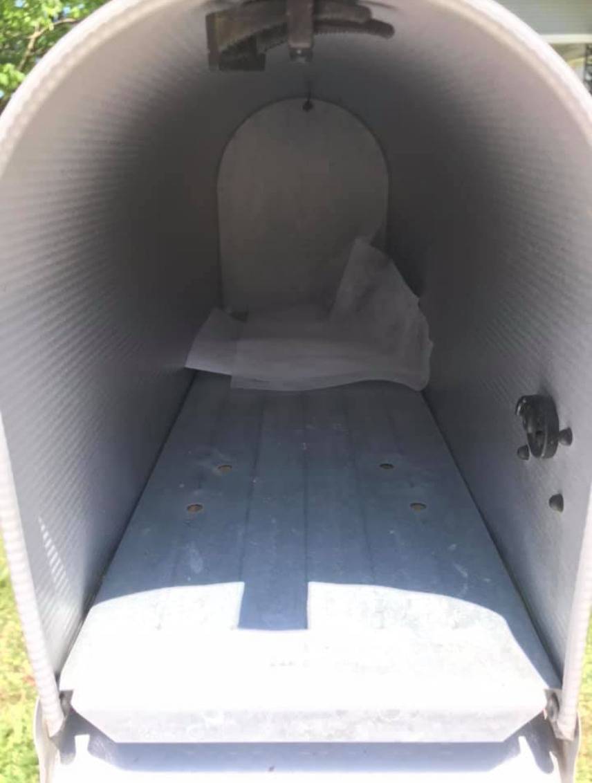 Multiple dryer sheets sit in the back of a mailbox.