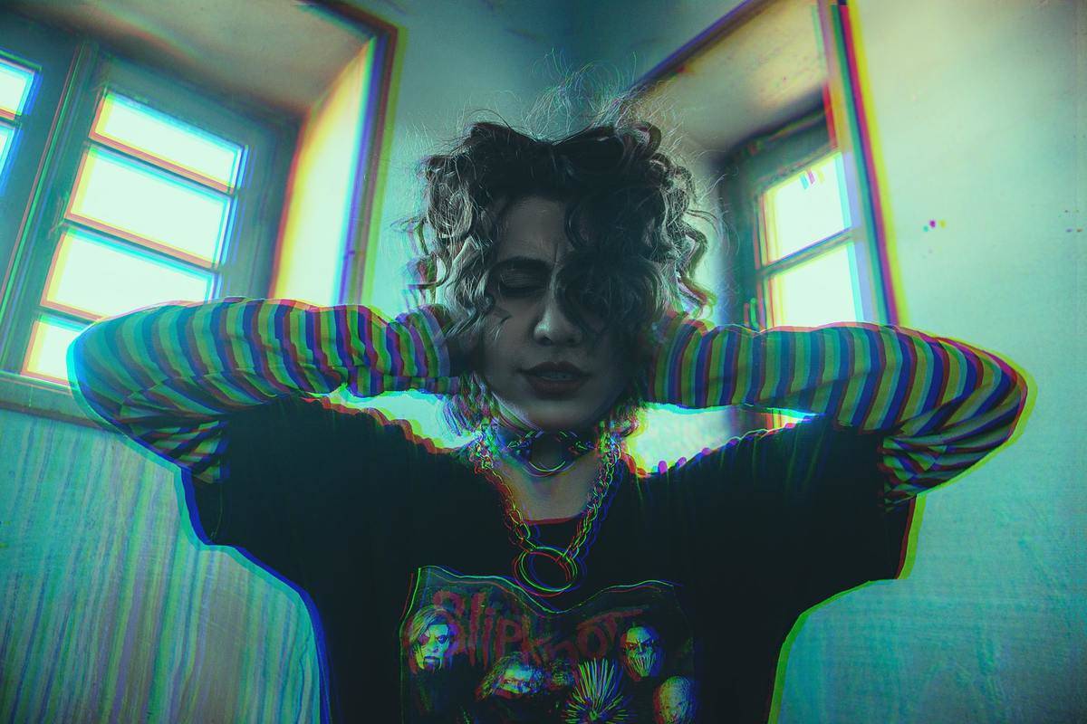 A woman covers her ears while listening to loud music.