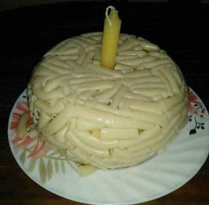 noodles formed together and put on a plate with a candle on top