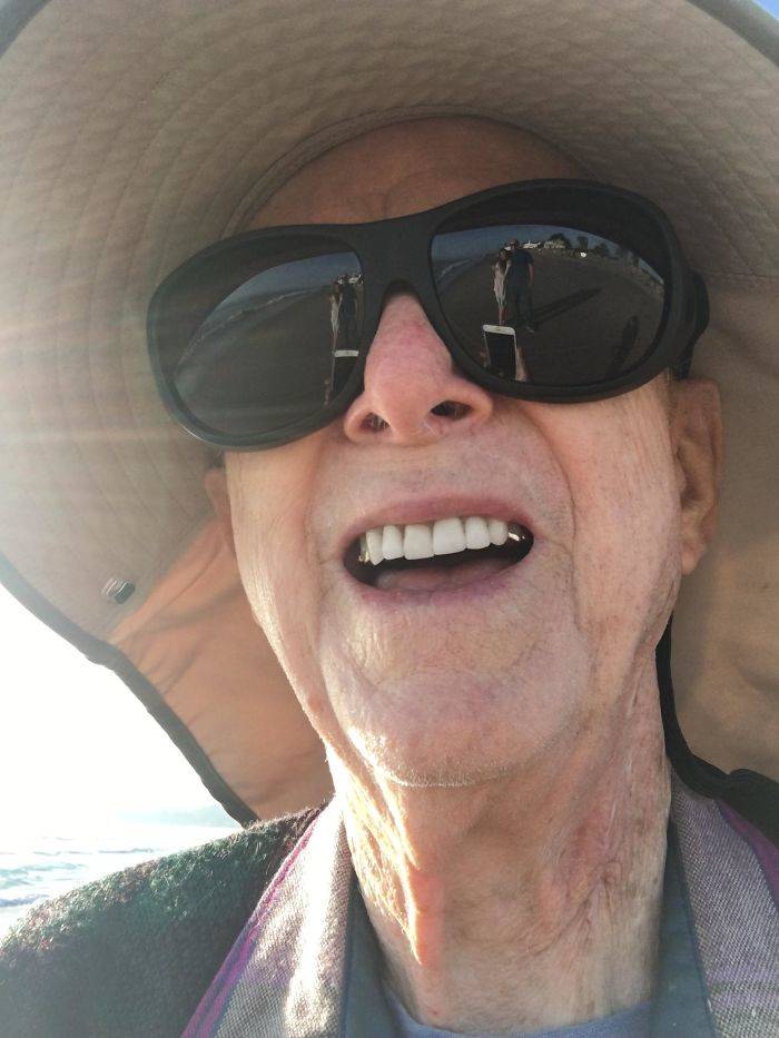 old man at beach taking photos