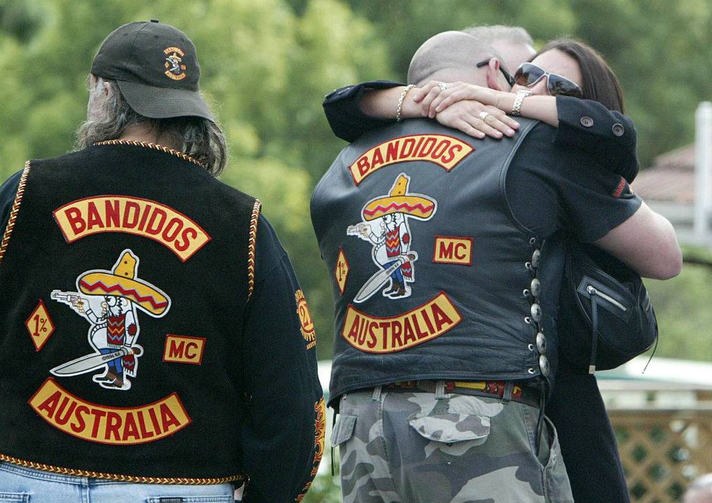 bandidos hugging a woman at a funeral
