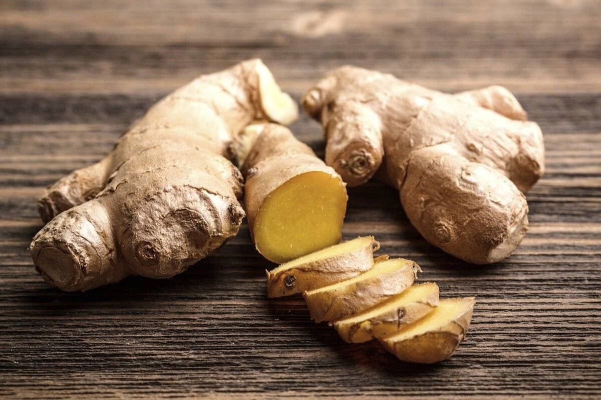 Part of a fresh ginger root is sliced into pieces.