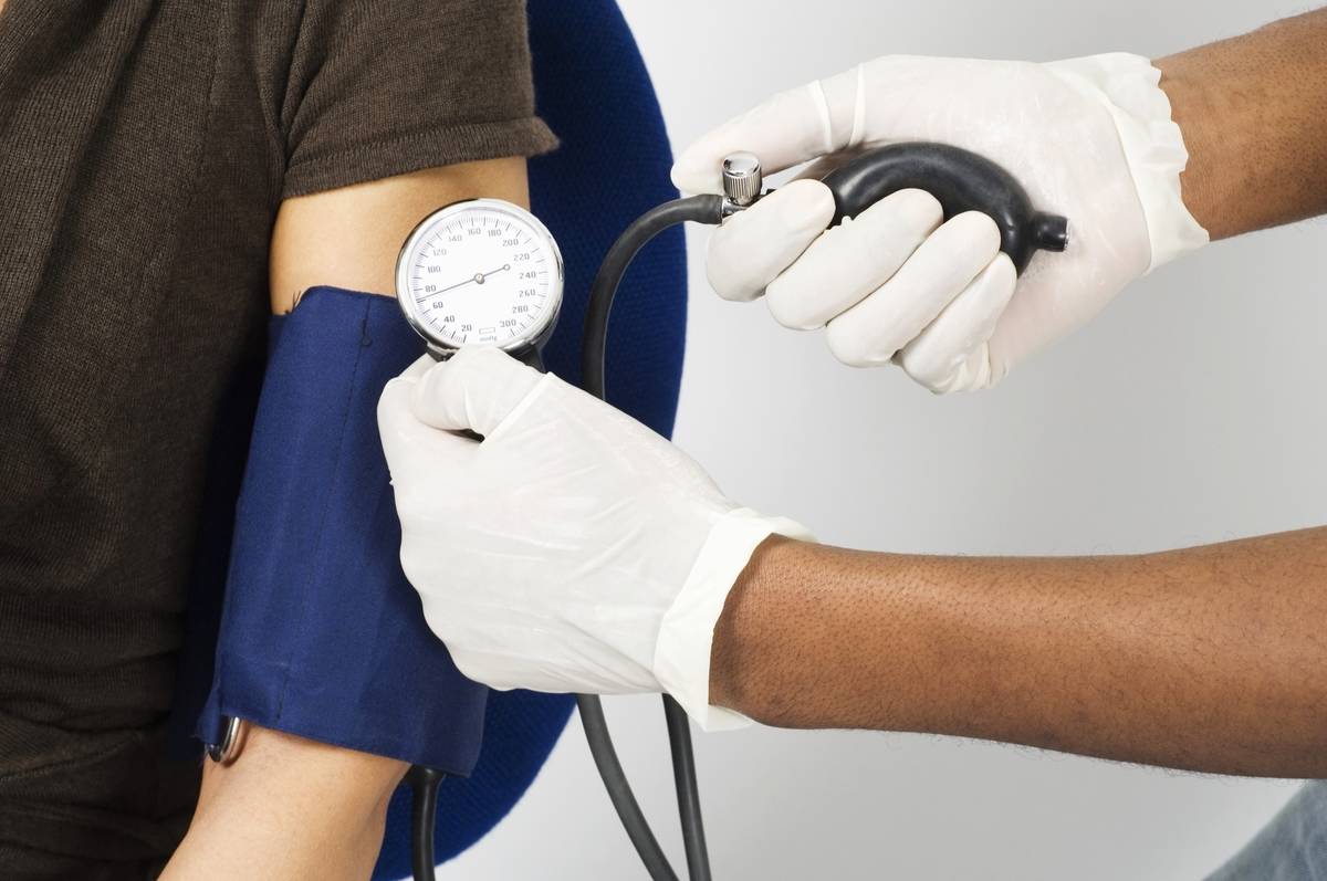 A doctor takes a woman's blood pressure.