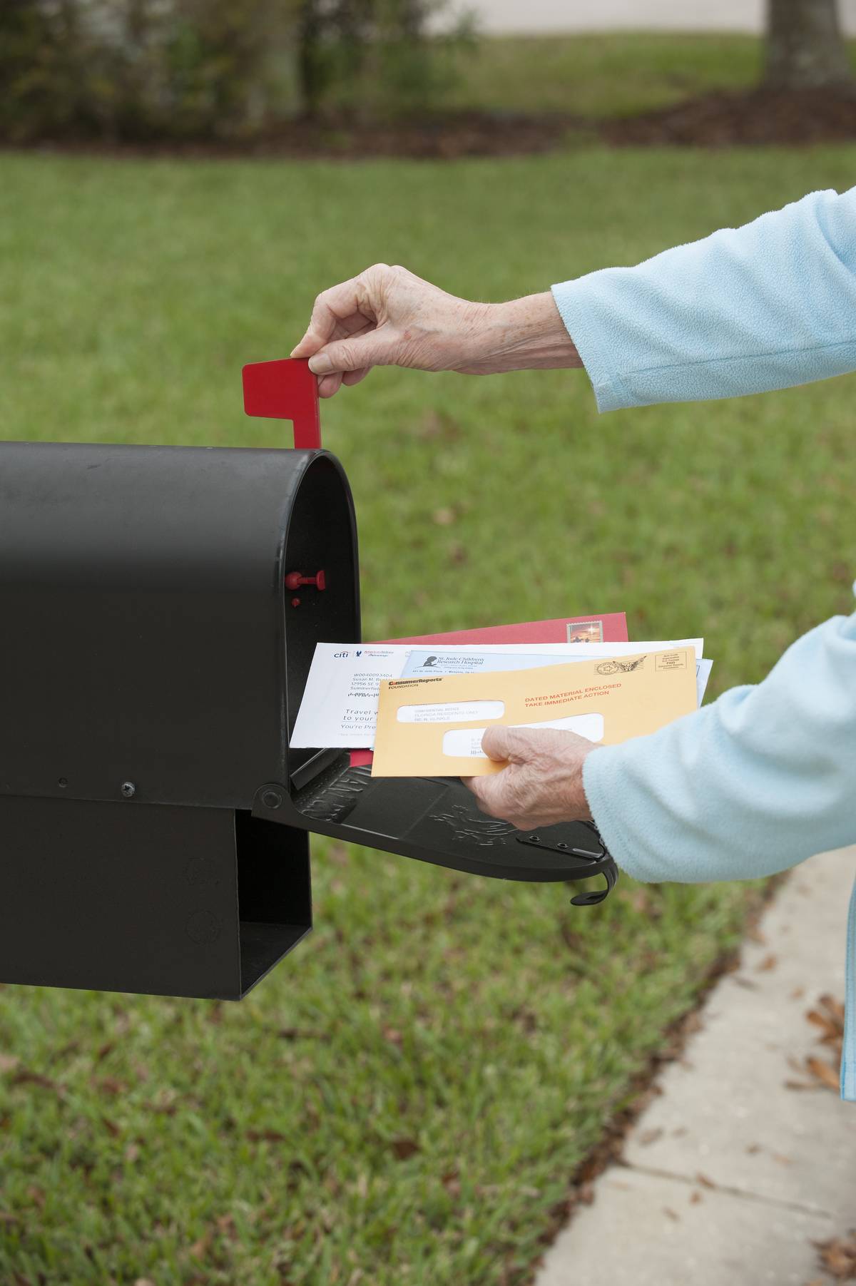 A person removes mail from a U.S. mailbox.