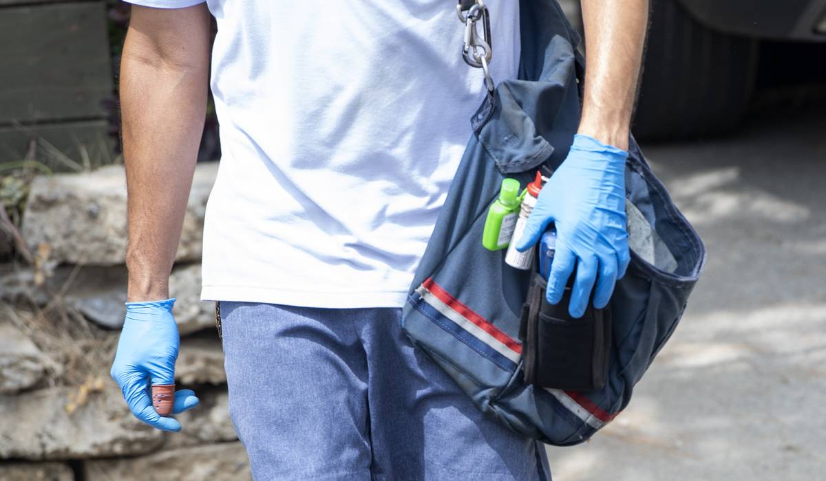 A mail carrier walks with his bag of mail.