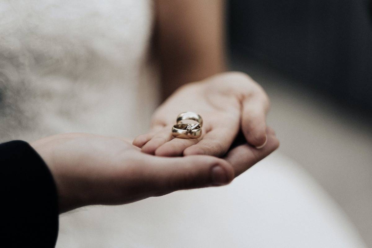 couple holding their wedding rings