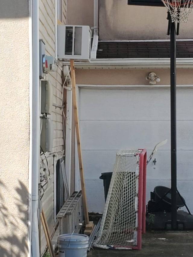 Air conditioner being held up by a wooden post