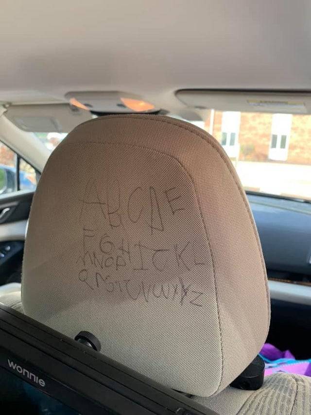 Letter of the alphabet written on the back of a car headrest.