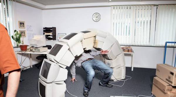 Computers stacked in a half-circle with a person doing the limbo underneath it