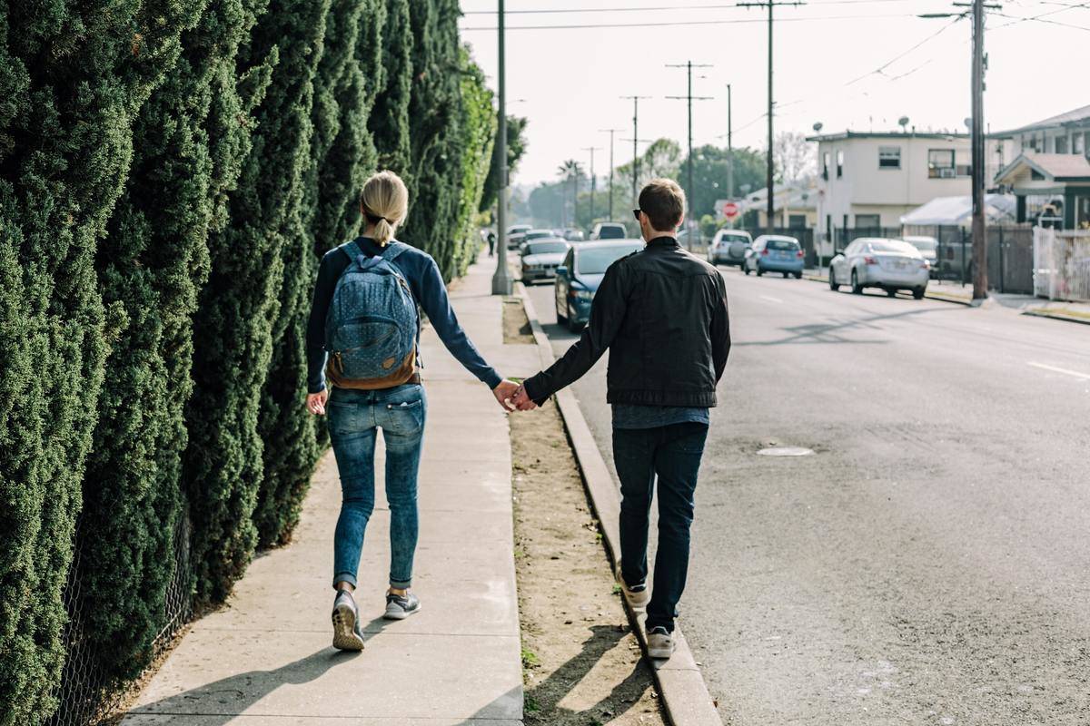 Couple holds hands walking away