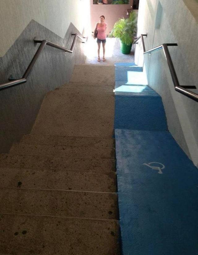 Dangerous and steep wheelchair ramp on top of one side of a staircase
