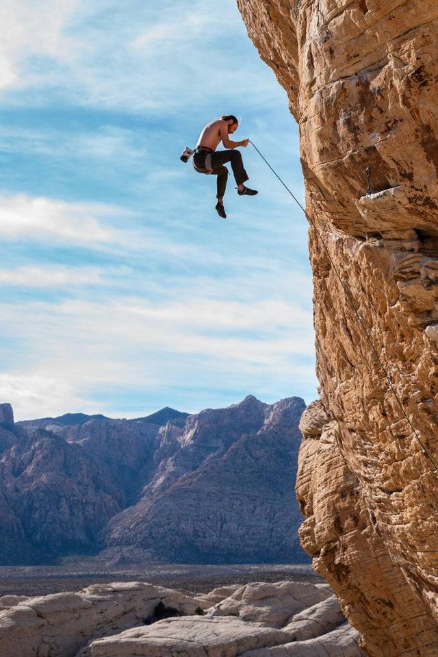 Man rock climbing photo snapped mid fall before his ropes catch him.